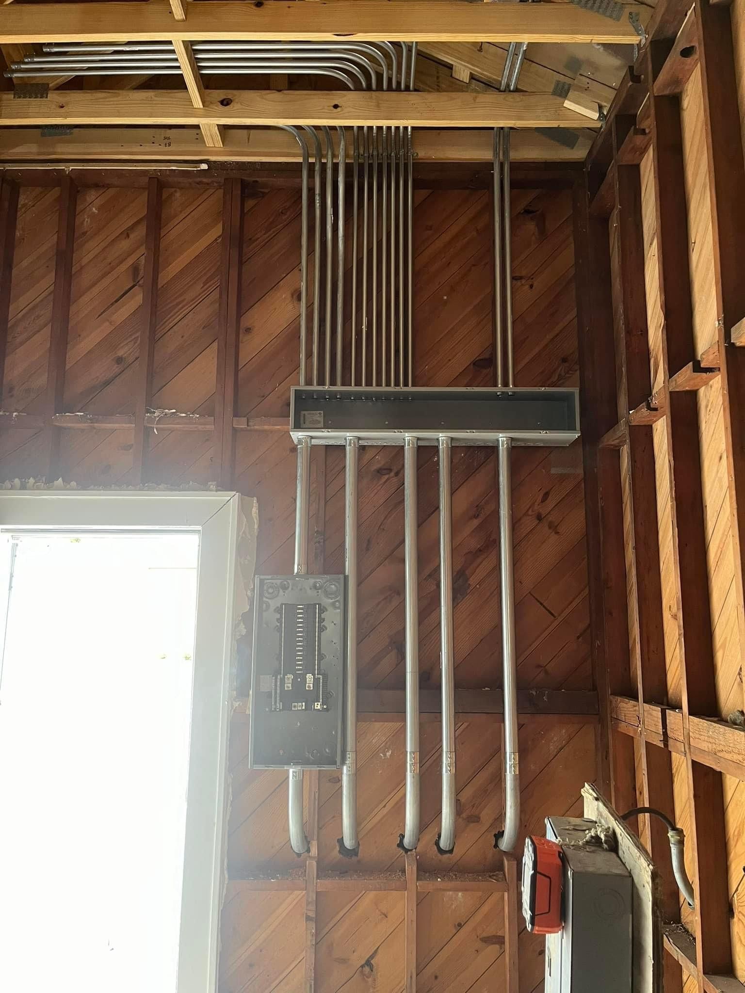 A wooden wall with electrical wires hanging from it