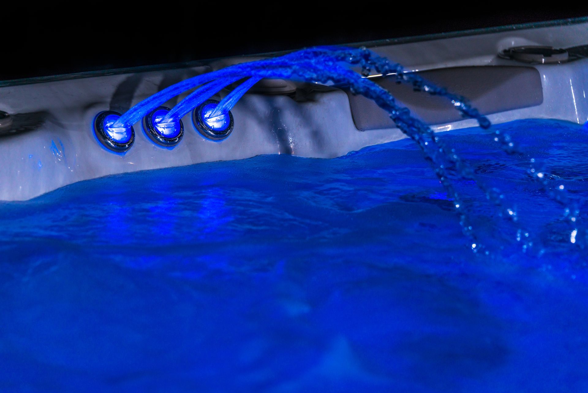 A hot tub with blue lights on it and water coming out of it.