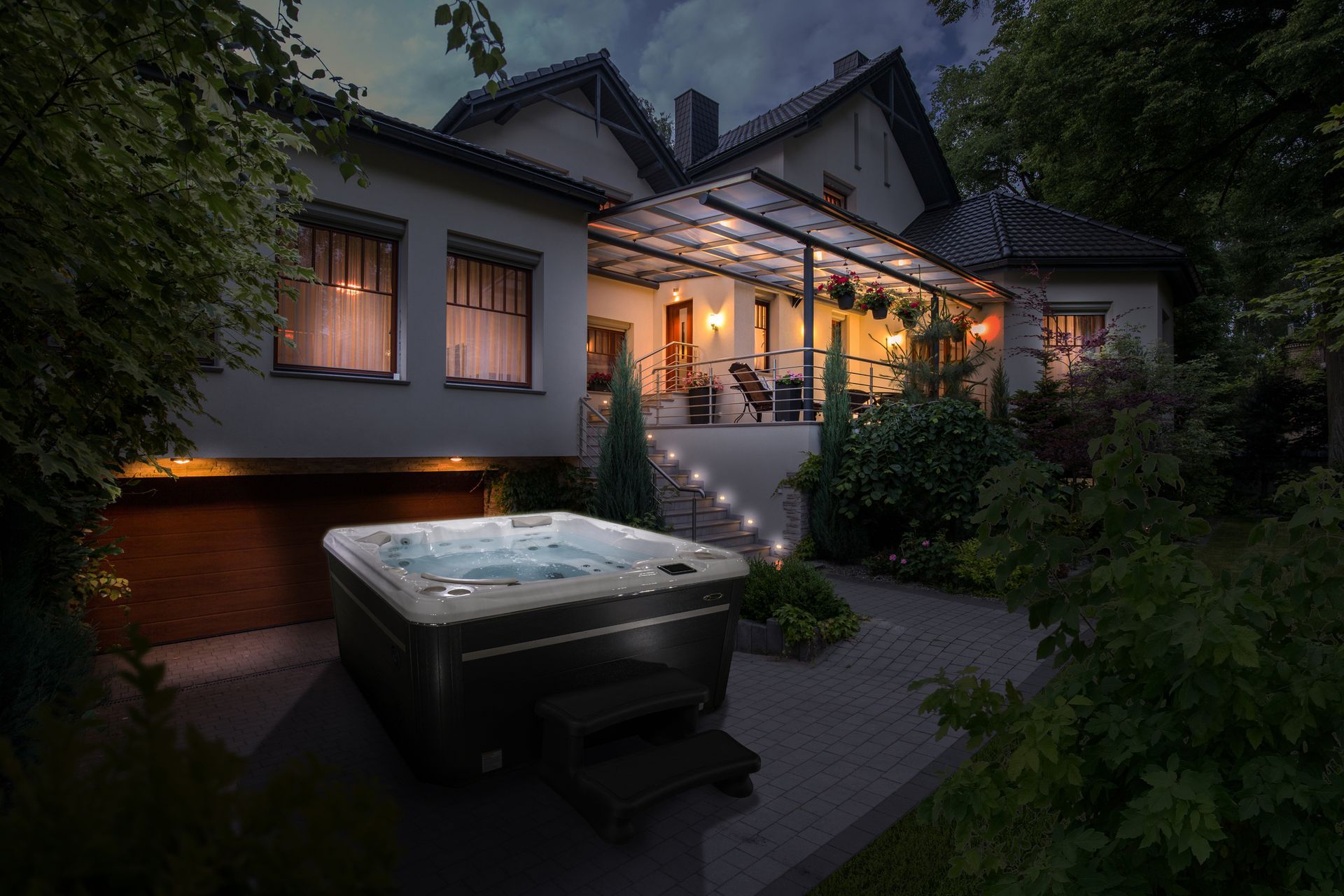 A hot tub is sitting in front of a house at night.