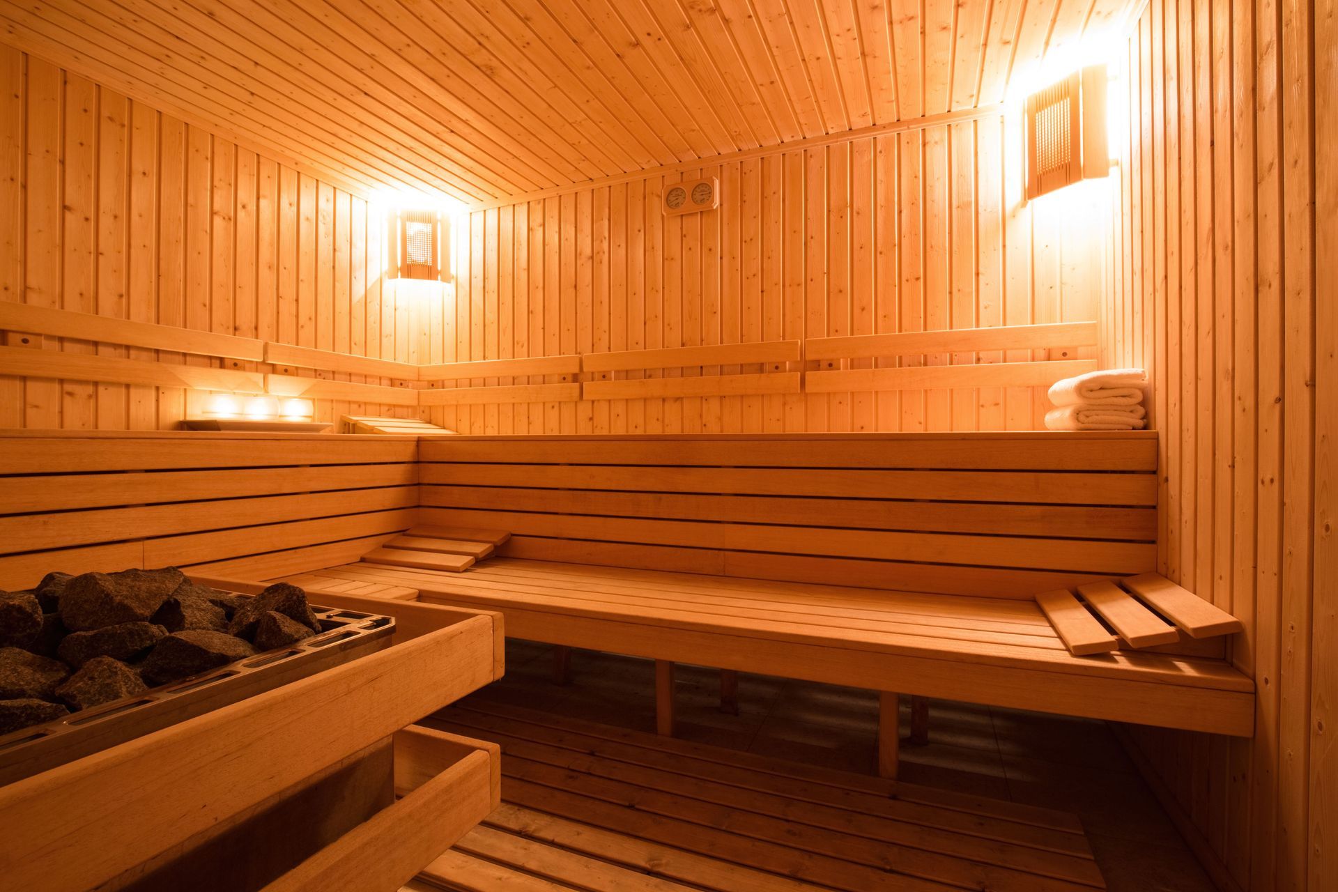 A wooden sauna with a lot of benches and candles.