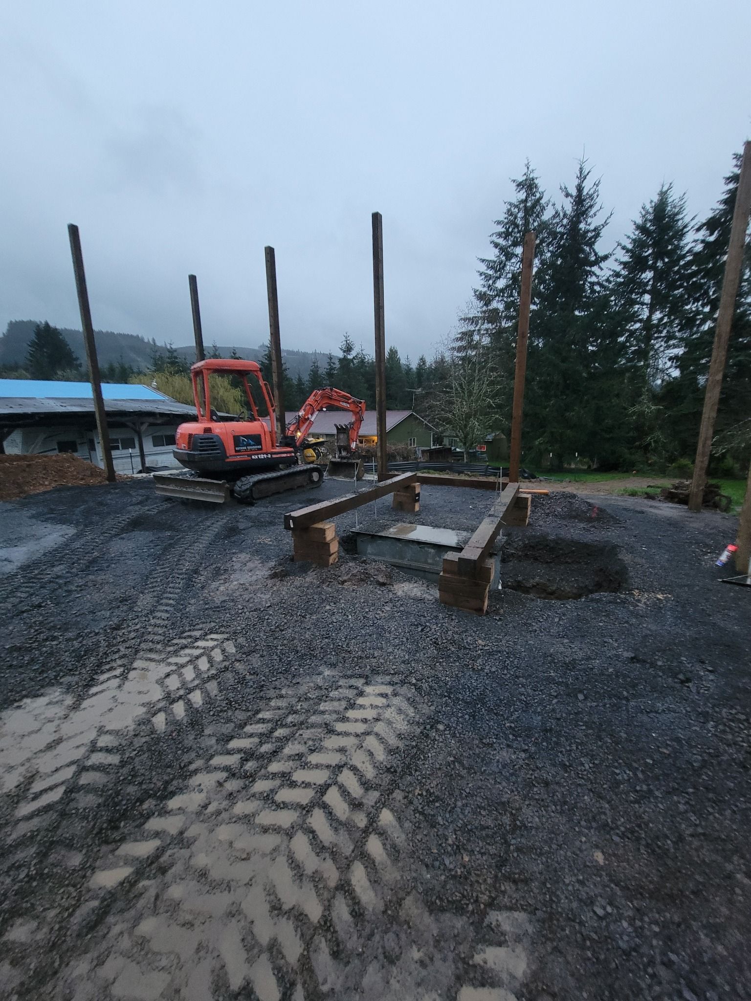 A large orange excavator is parked in a gravel lot.