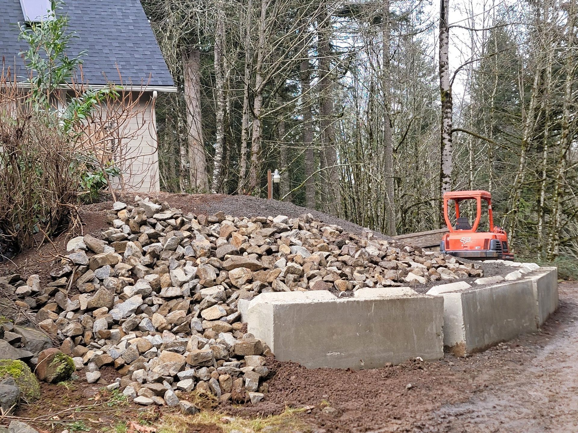 A pile of rocks is sitting next to a small excavator.