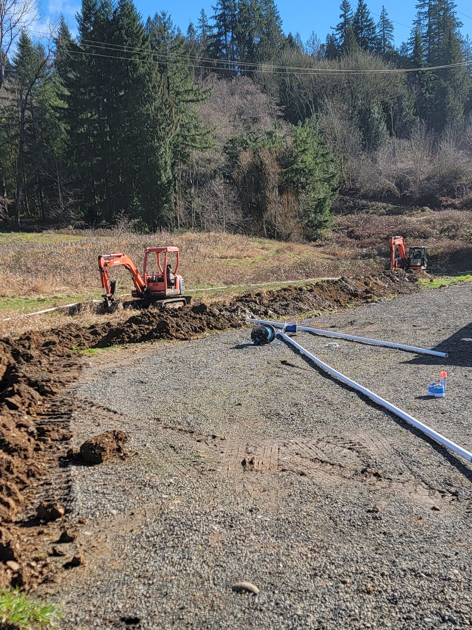 An excavator is digging a hole in the dirt in a field.