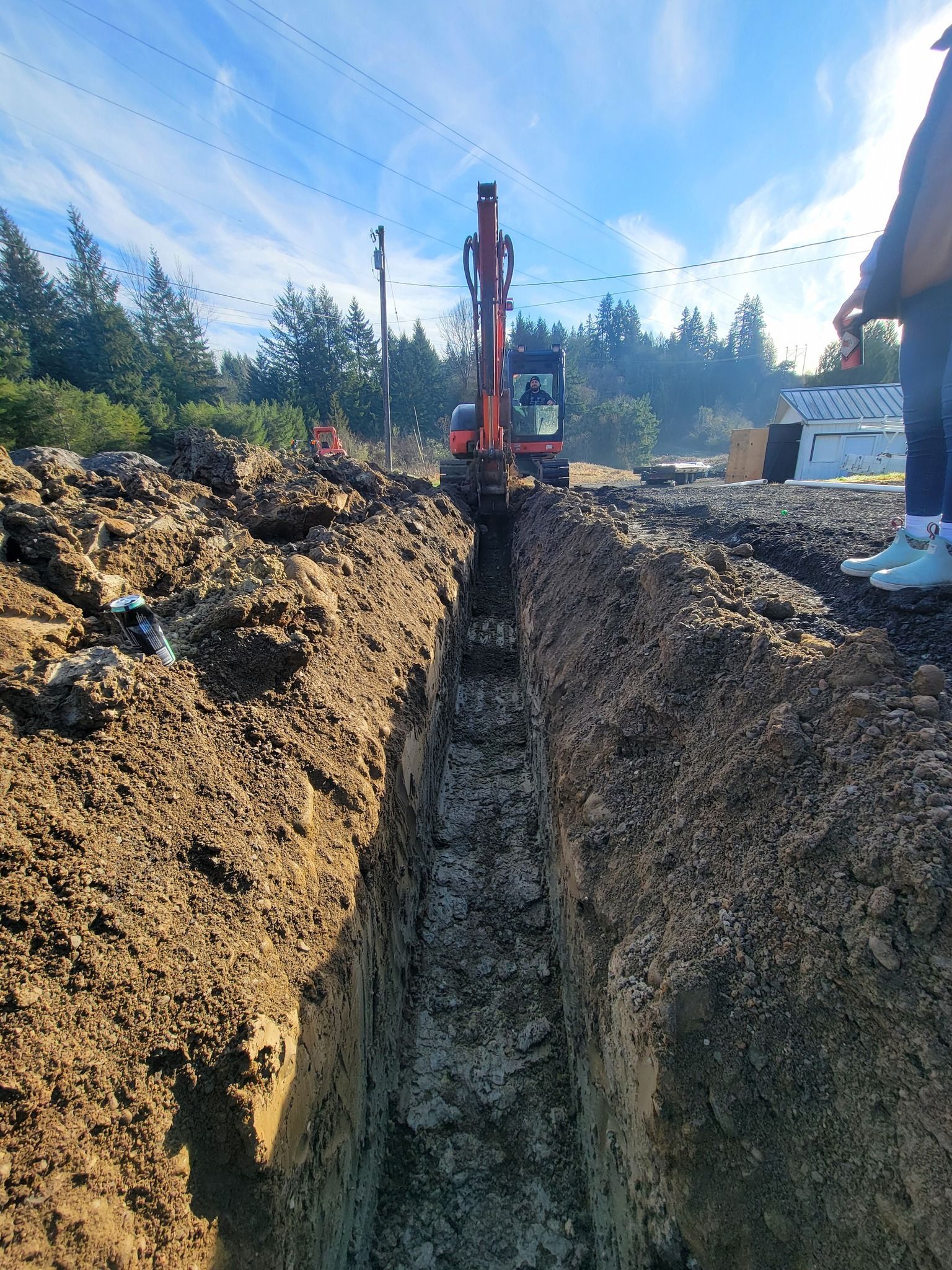 An excavator is digging a trench in the dirt.