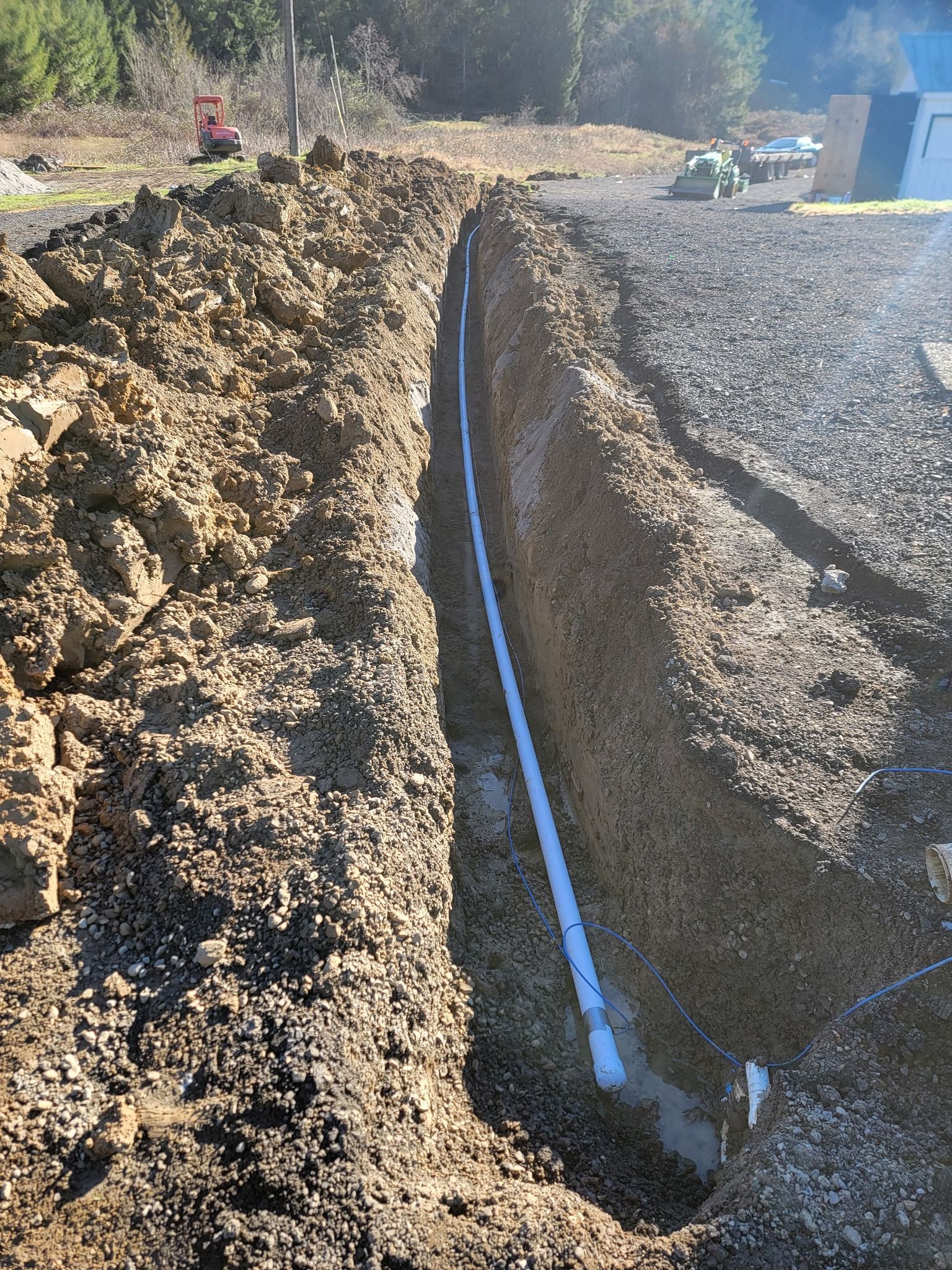 A pipe is being installed in a trench in the dirt.