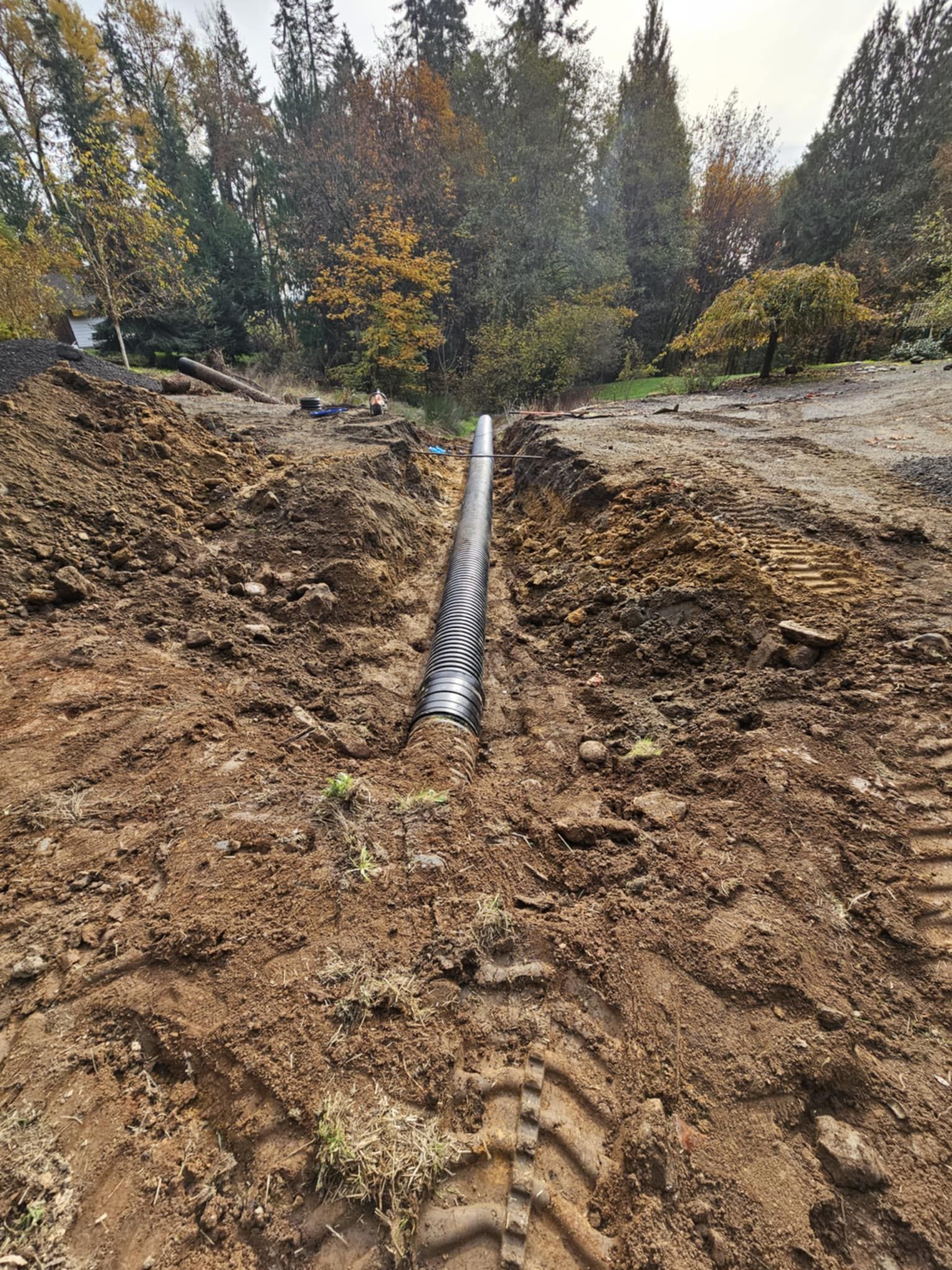 A pipe is being installed in the dirt in a field.