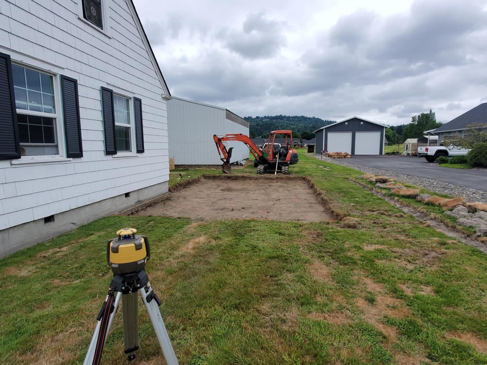 A tripod is sitting in the grass in front of a house.