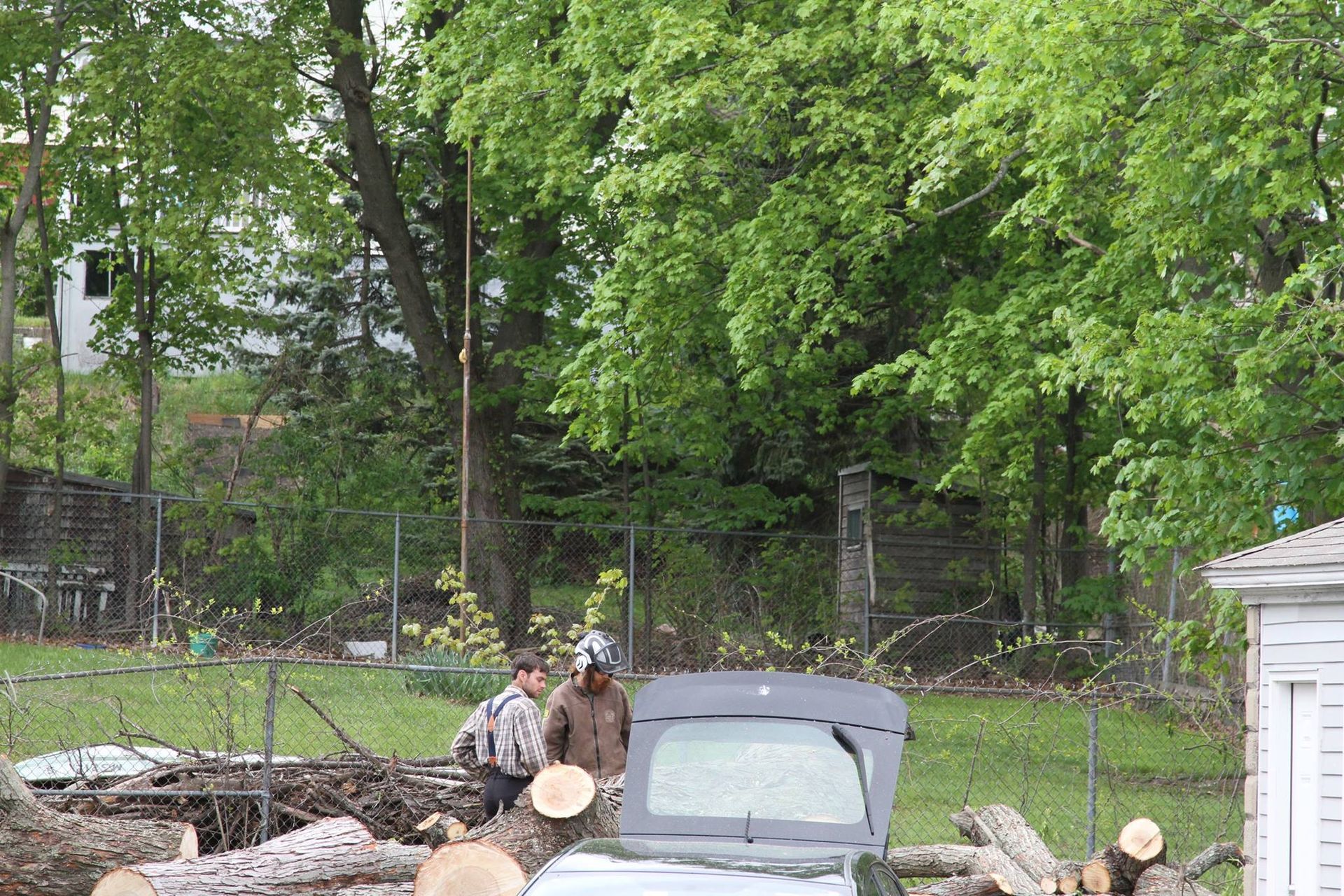A man is standing next to a car with the trunk open.