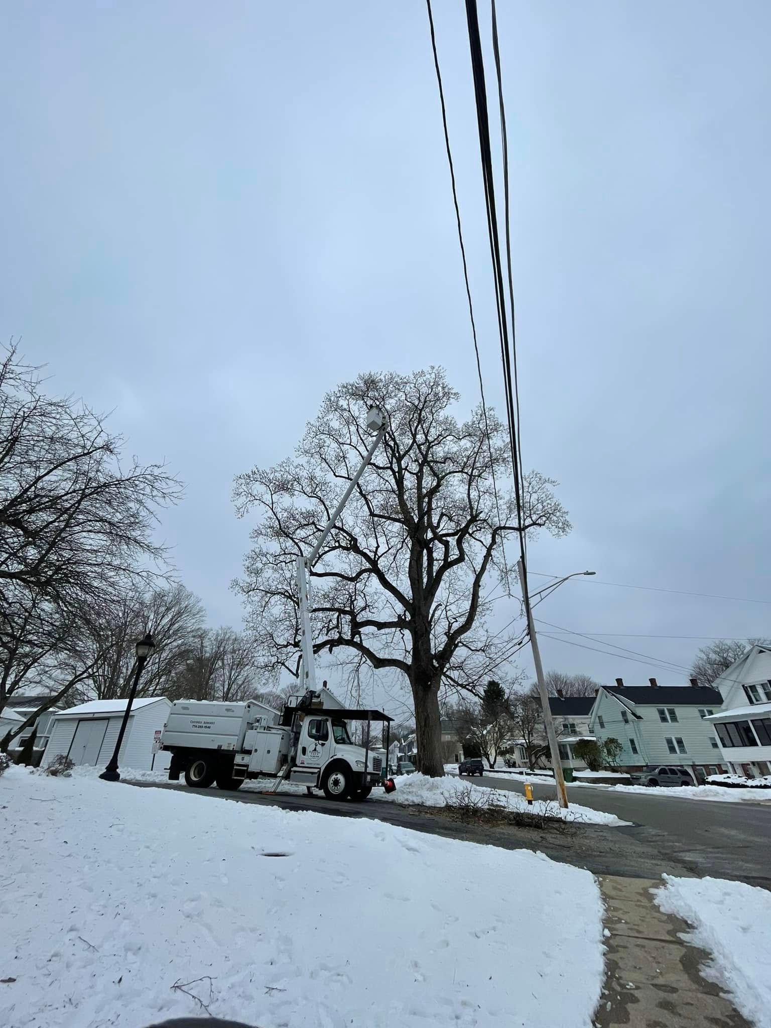 A garbage truck is parked on the side of the road in the snow.