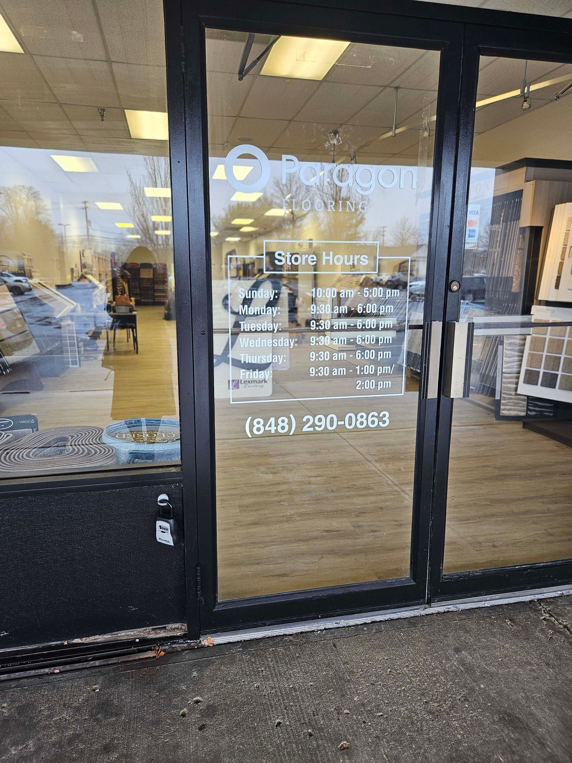 a store front with a glass door and a phone number on it .