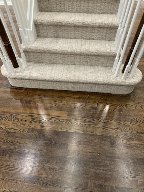 a close up of a staircase with a carpet on the steps and a wooden floor .