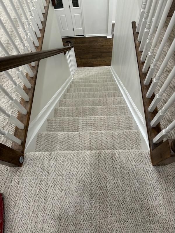 a staircase with a carpeted staircase and a wooden railing .