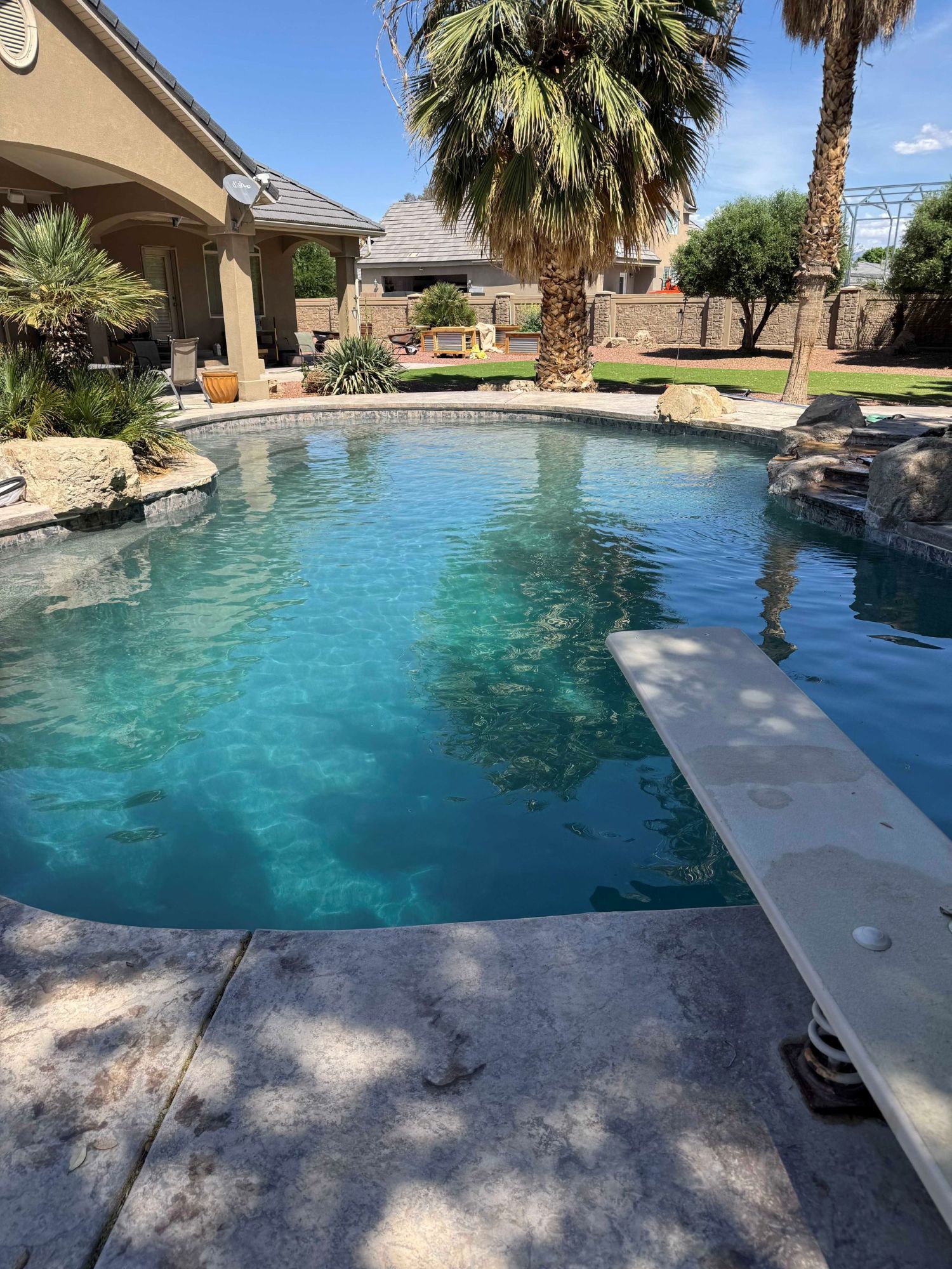 A large swimming pool with a diving board in the middle of it.