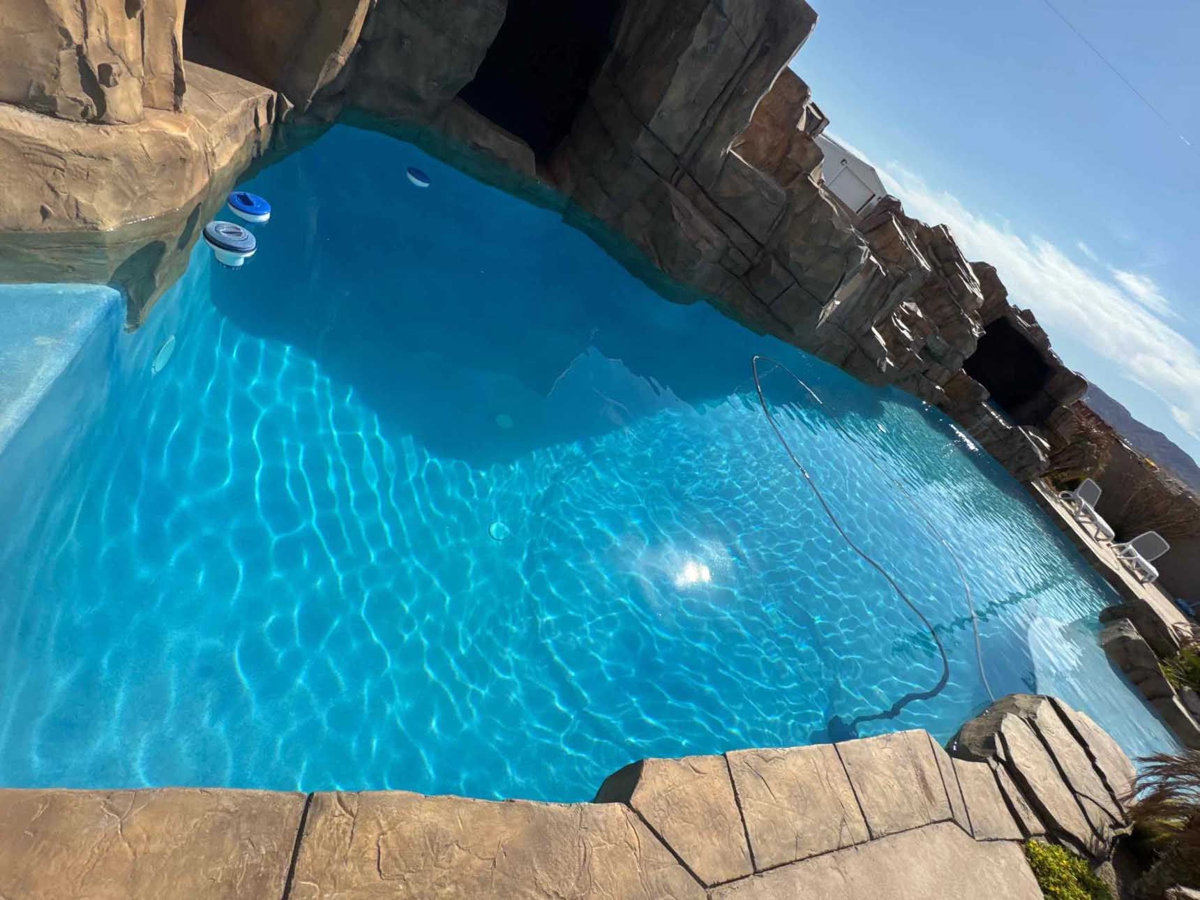 A large swimming pool surrounded by rocks and steps