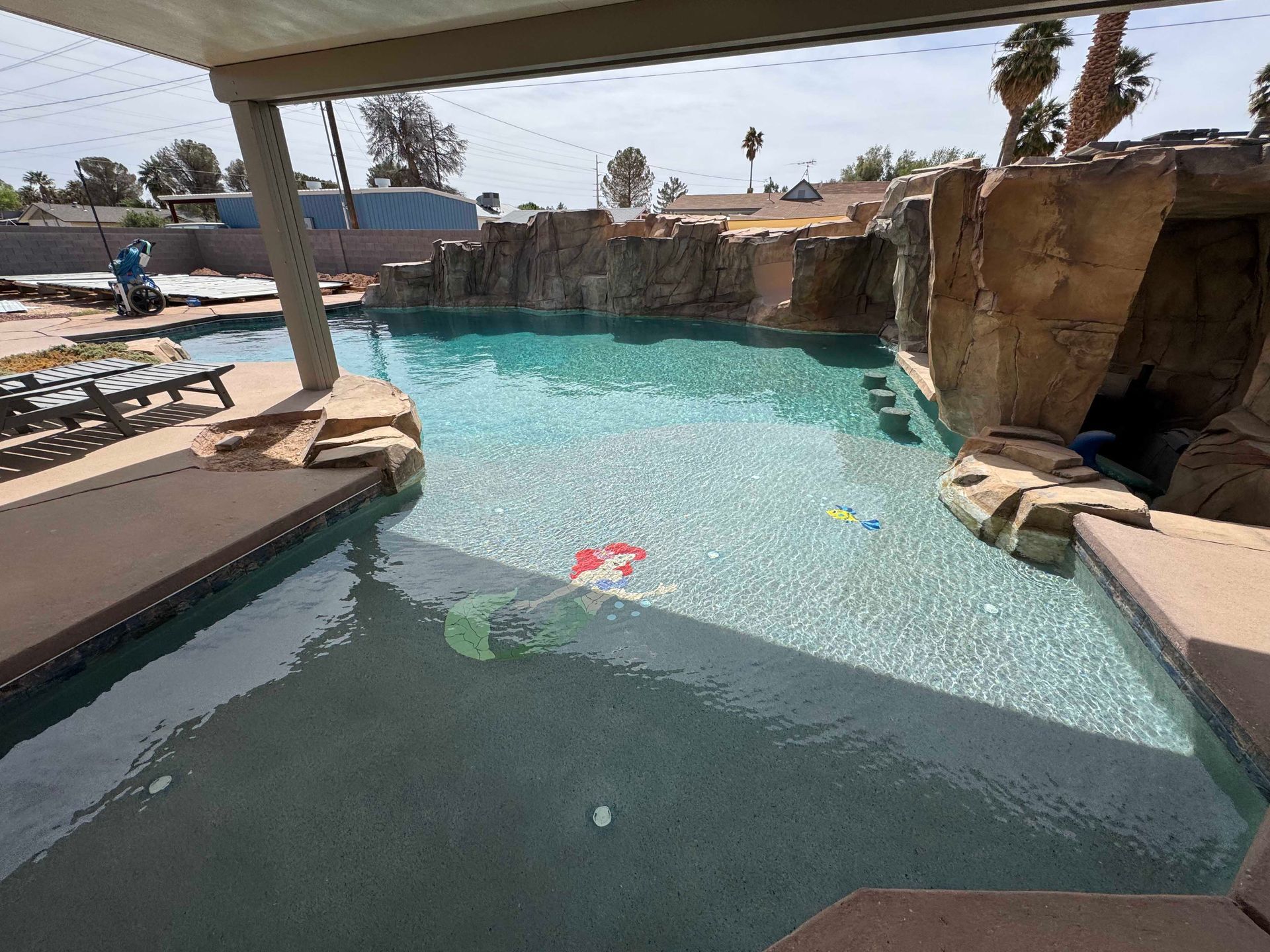 There is a large swimming pool with a waterfall in the background.