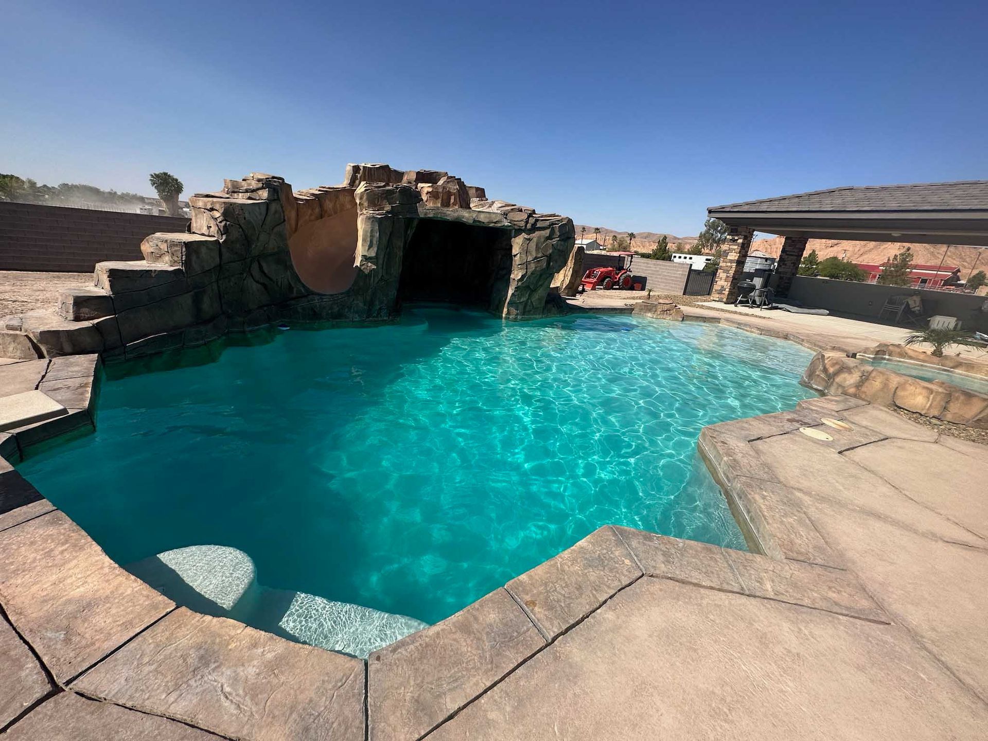 A large swimming pool with a cave in the middle of it.
