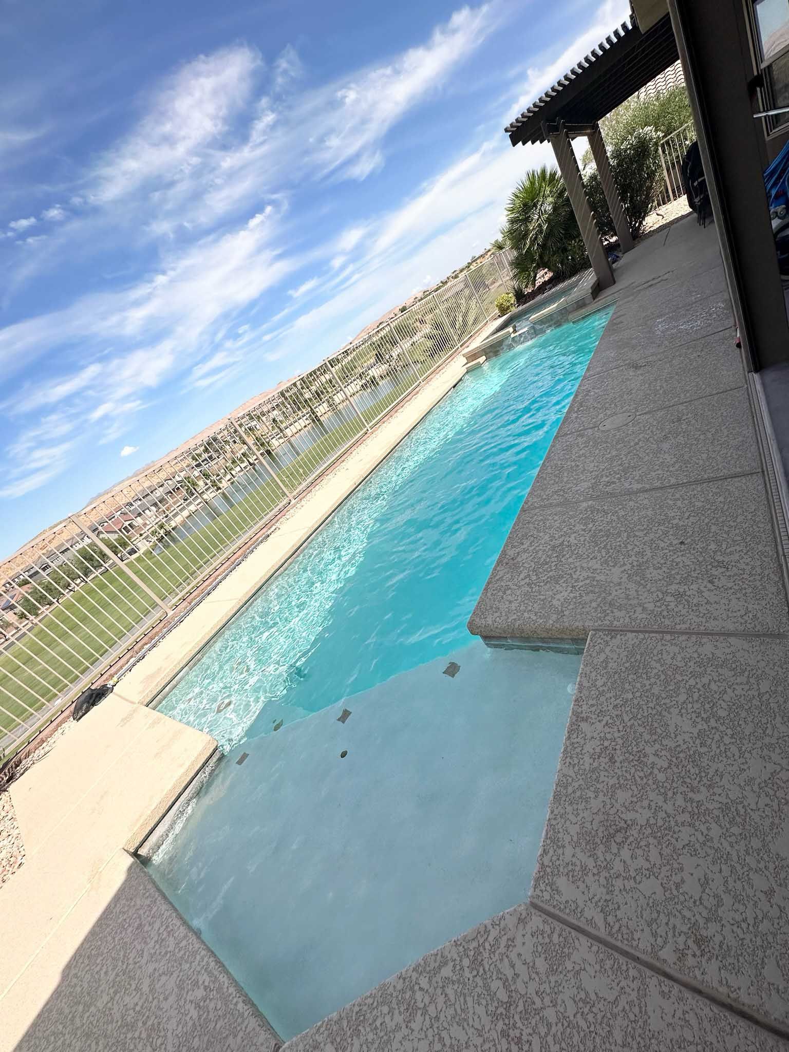 A large swimming pool with a hot tub in the middle of it.