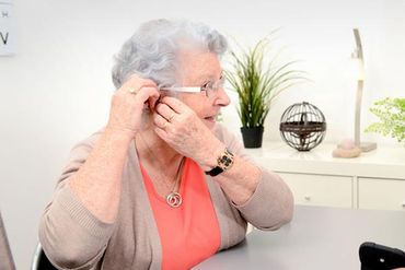 Old Lady Putting Hearing Aid