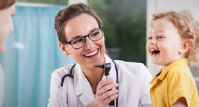 A woman with a stethoscope on her neck and a child laughing