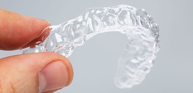 A person is holding a clear brace in their hand