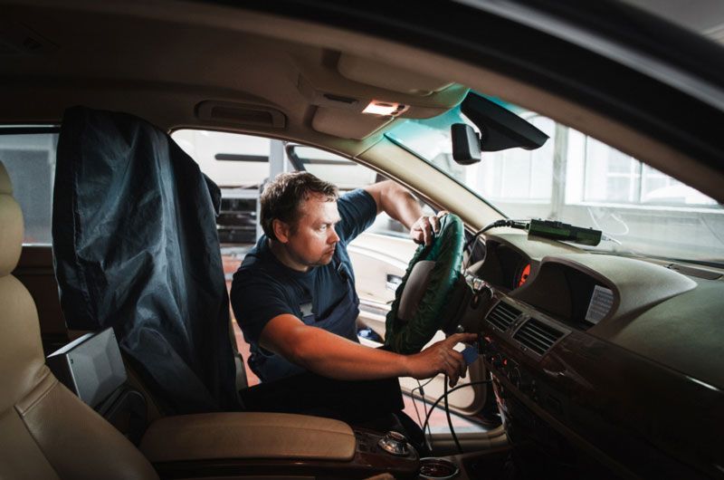 Technician installing a car security system