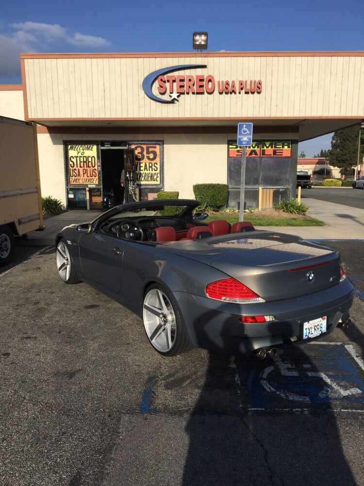 Porsche parked in front of a car audio installation shop
