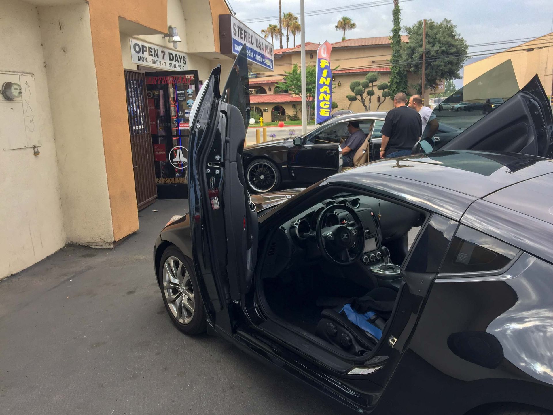 Vehicles parked in front of a car audio installation shop
