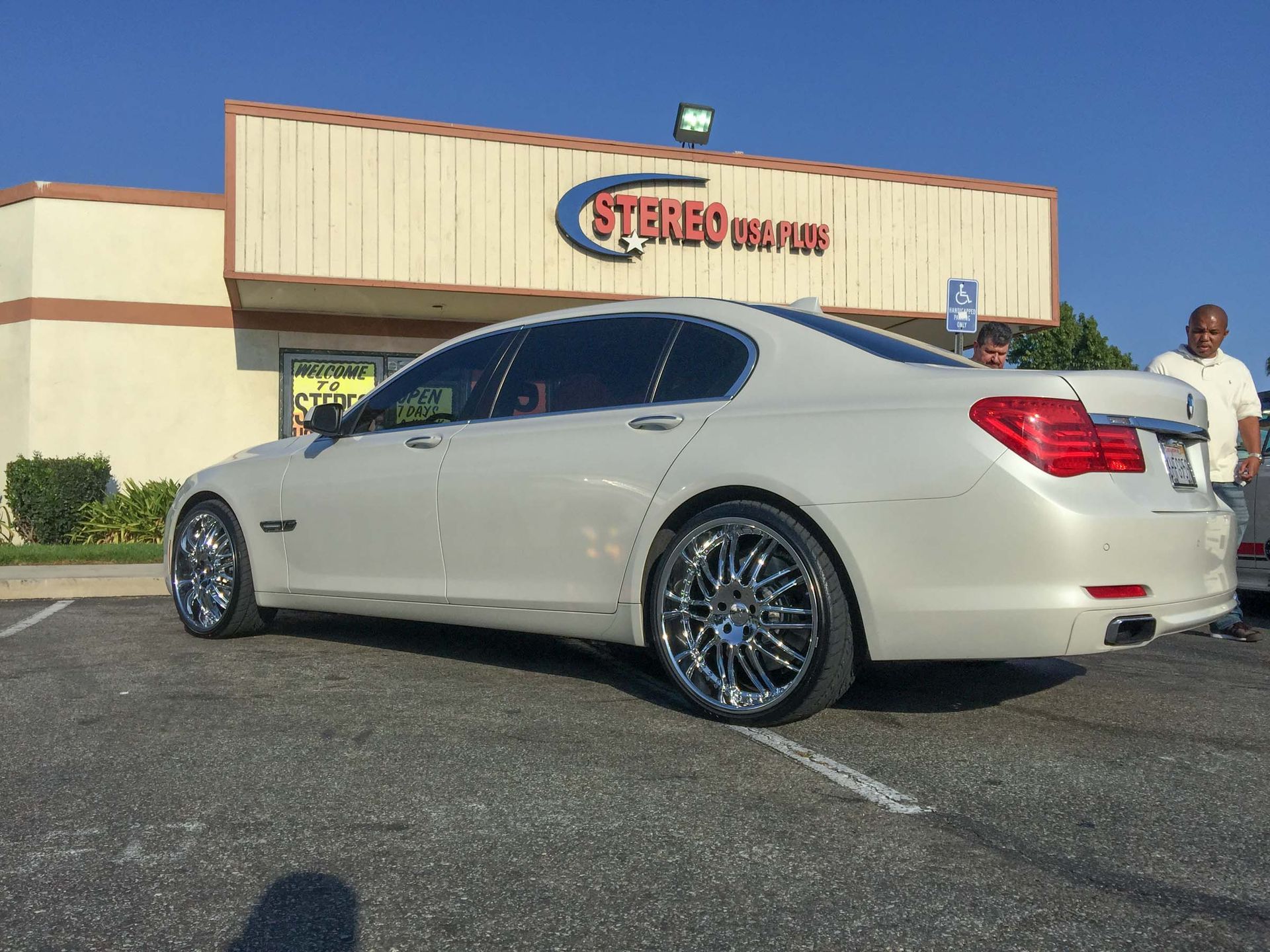 BMW parked in front of a car audio installation shop