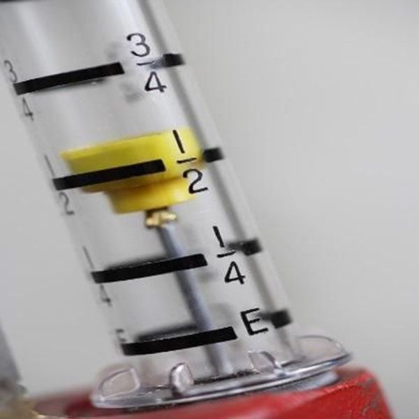 Clear tube with yellow float indicating a liquid level at the 1/2 mark, black markings on the tube, red base.