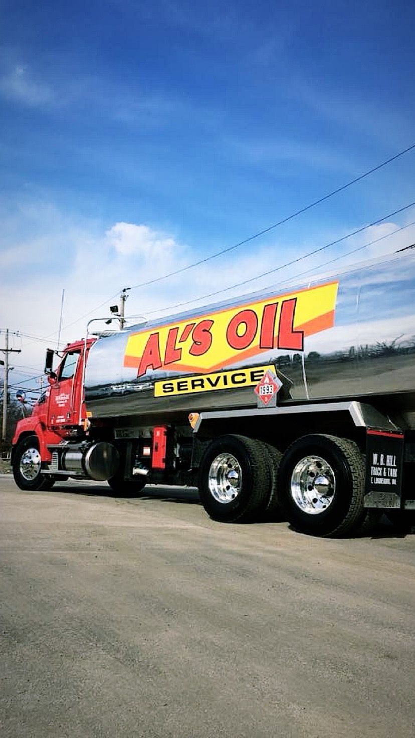 Red Al's Oil Service truck on a street, silver tank, blue sky, and yellow banner.