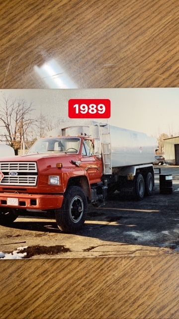 1989 red tanker truck, parked outside, with a silver tank.