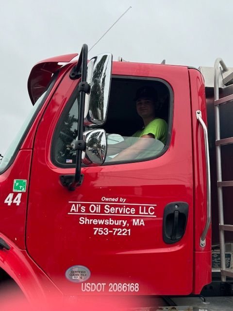 Man driving a red oil truck for Al's Oil Service LLC in Shrewsbury, MA. Truck has number 44 on the side.