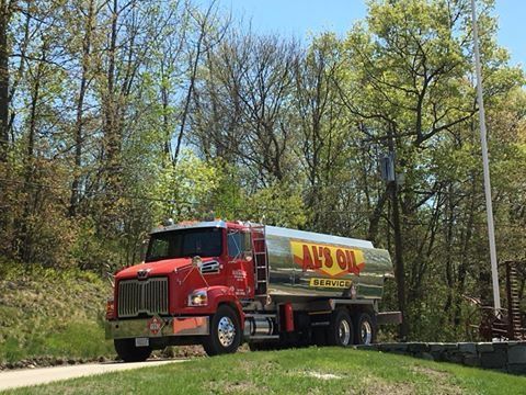 Red Jay's Oil tanker truck on a tree-lined road, delivering fuel.