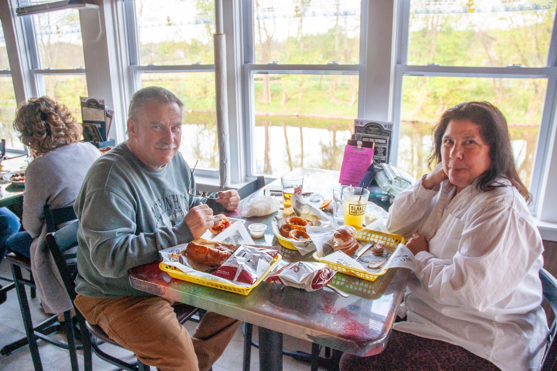 A man and a woman are sitting at a table in a restaurant eating food.