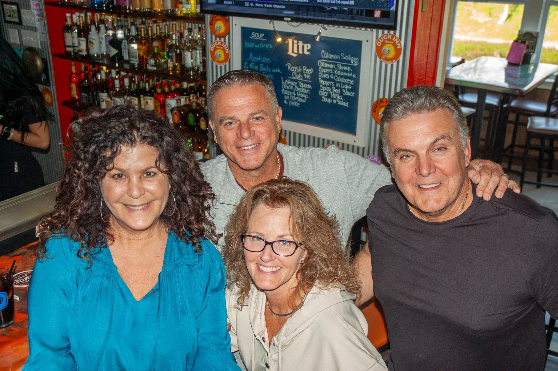 A group of people are posing for a picture in a bar.