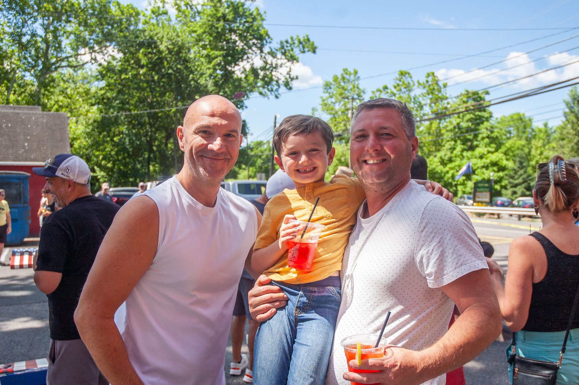 Three men are posing for a picture with a little boy.