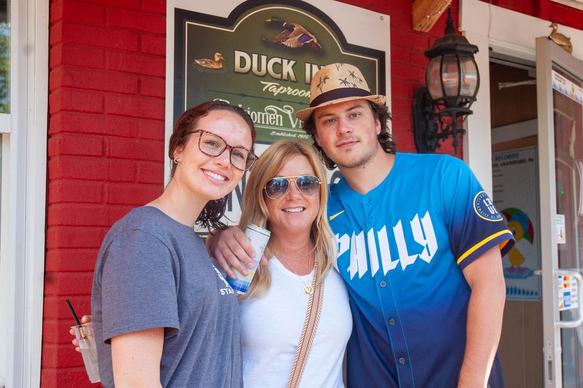 Three people posing for a picture in front of a duck inn