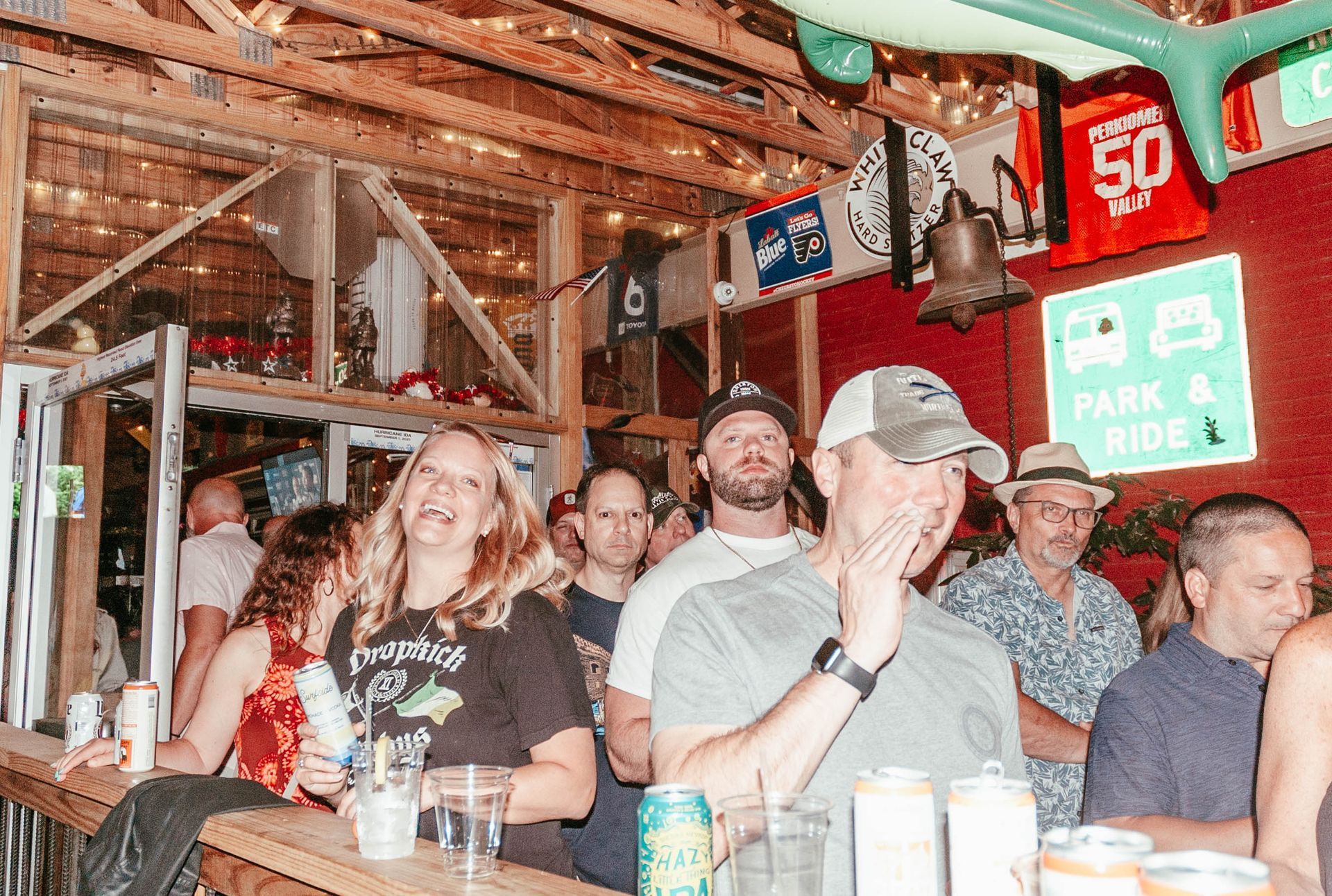 A group of people are sitting at a bar drinking beer.