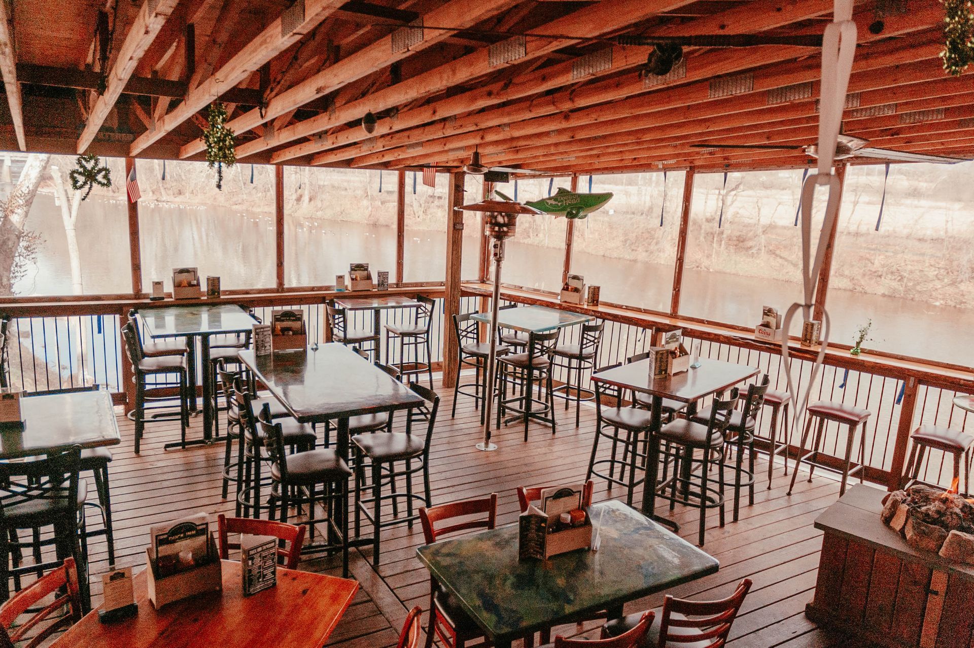 A restaurant with tables and chairs and a view of the water.