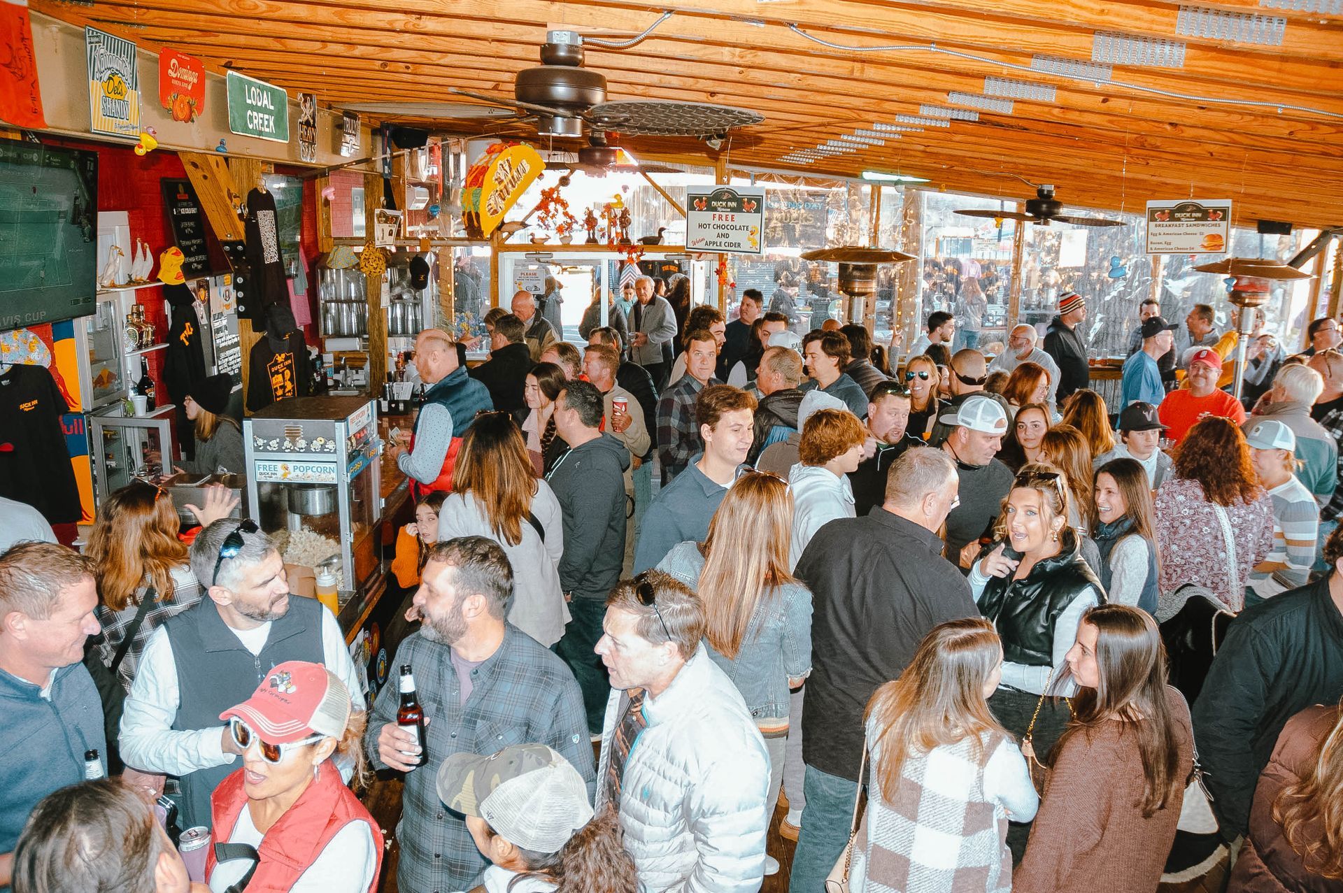A large group of people are gathered in a bar.