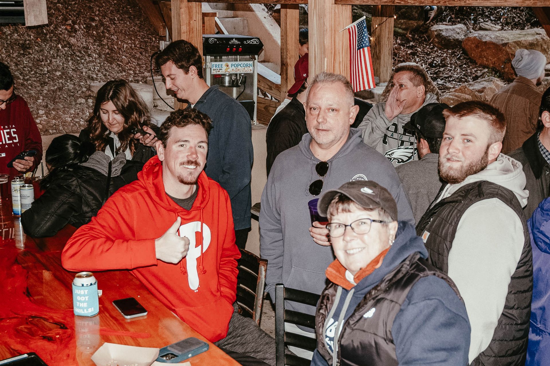 A group of people are standing around a table in a bar.