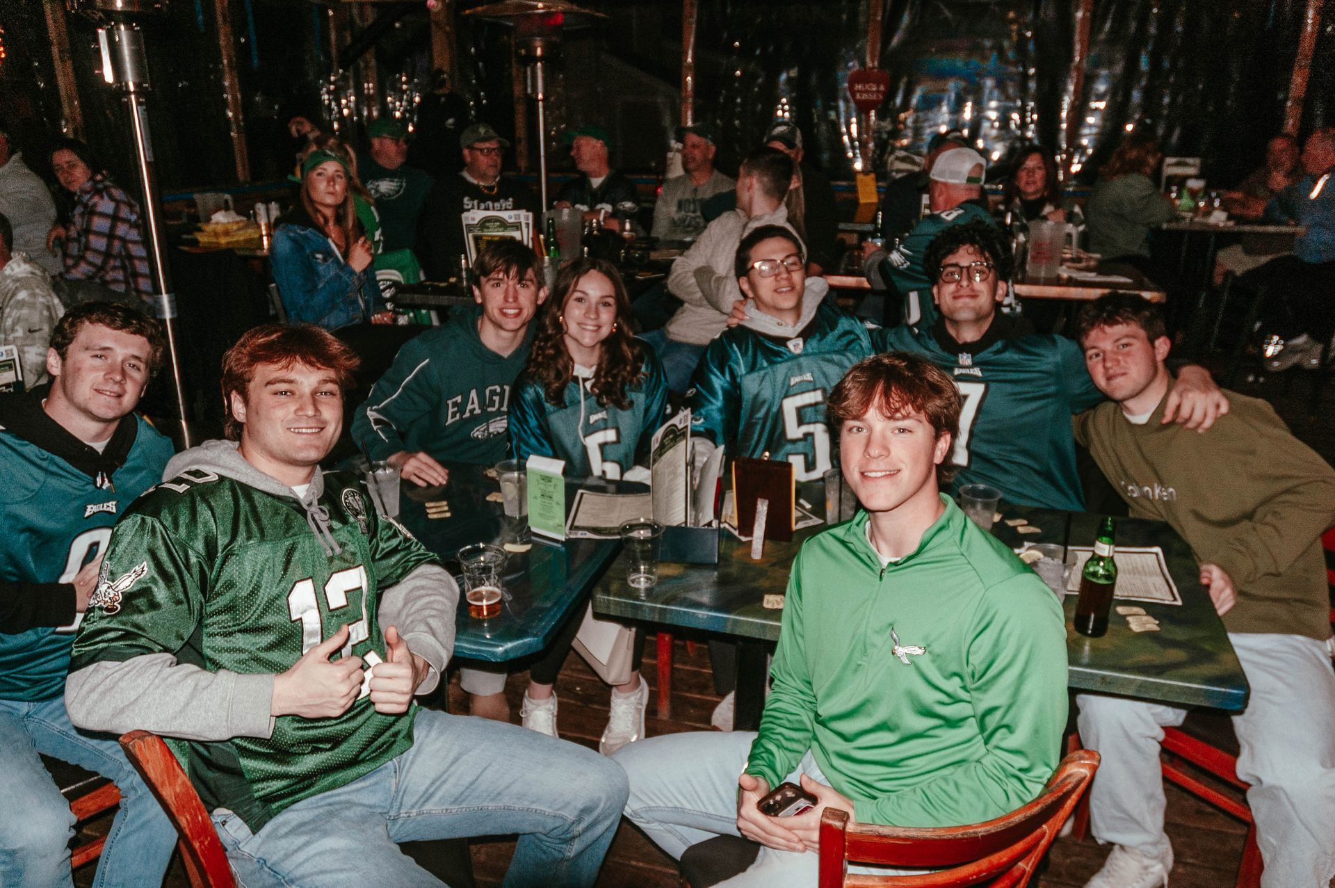 A group of people are sitting at tables in a restaurant.