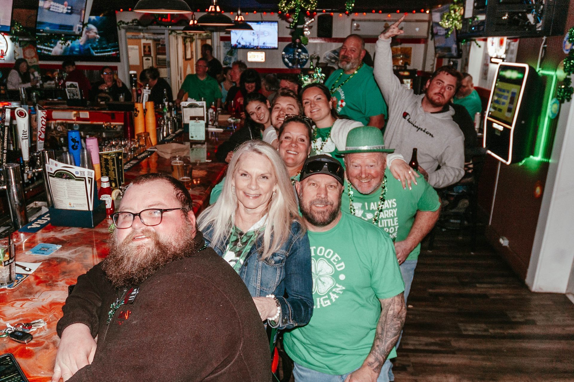 A group of people are posing for a picture in a bar.