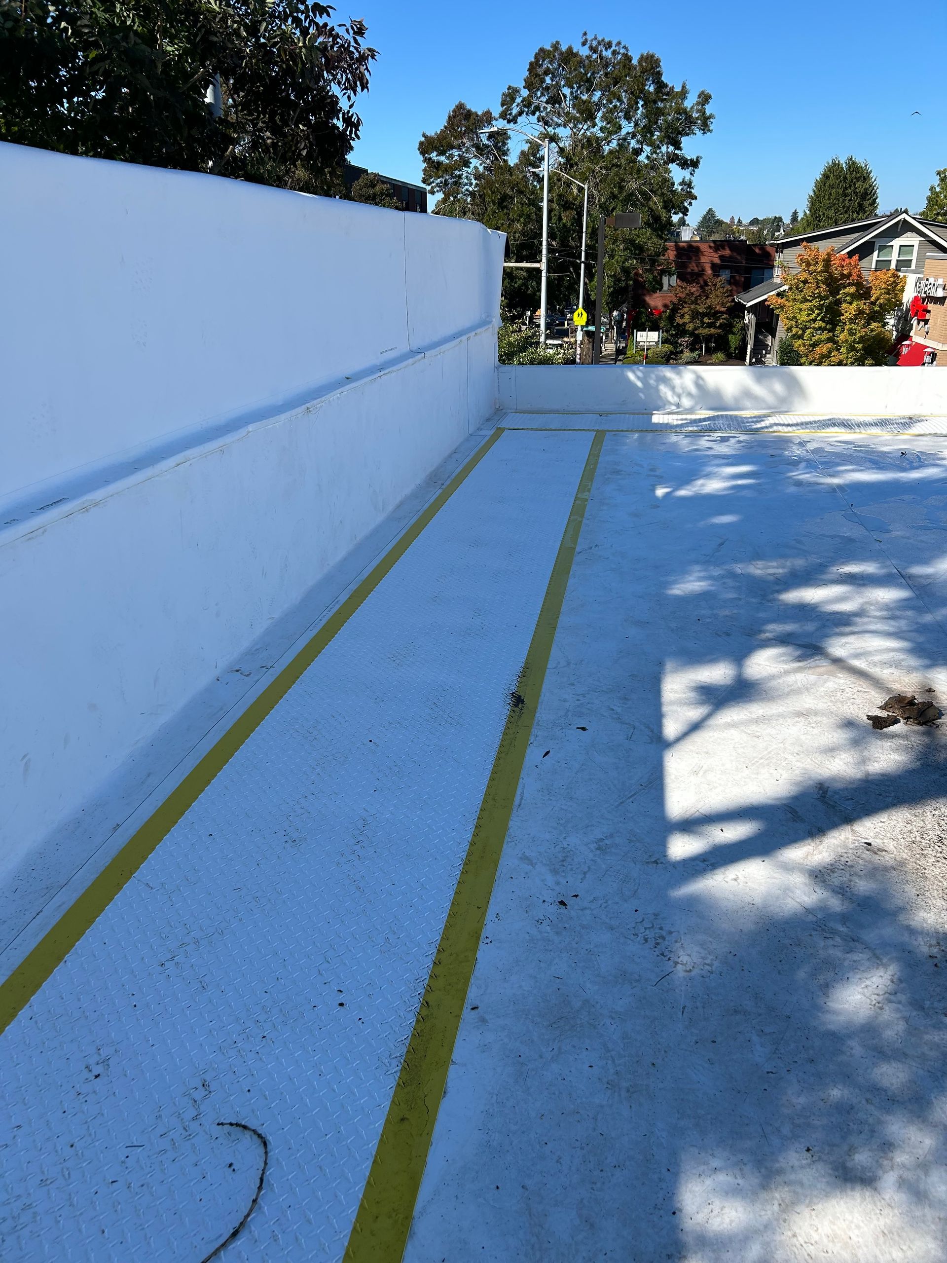 Blue painted steps with yellow stripes leading to an outdoor courtyard in sunlight
