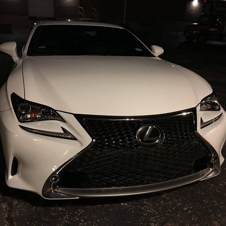 White Lexus RC coupe, front view, black grill, night setting.