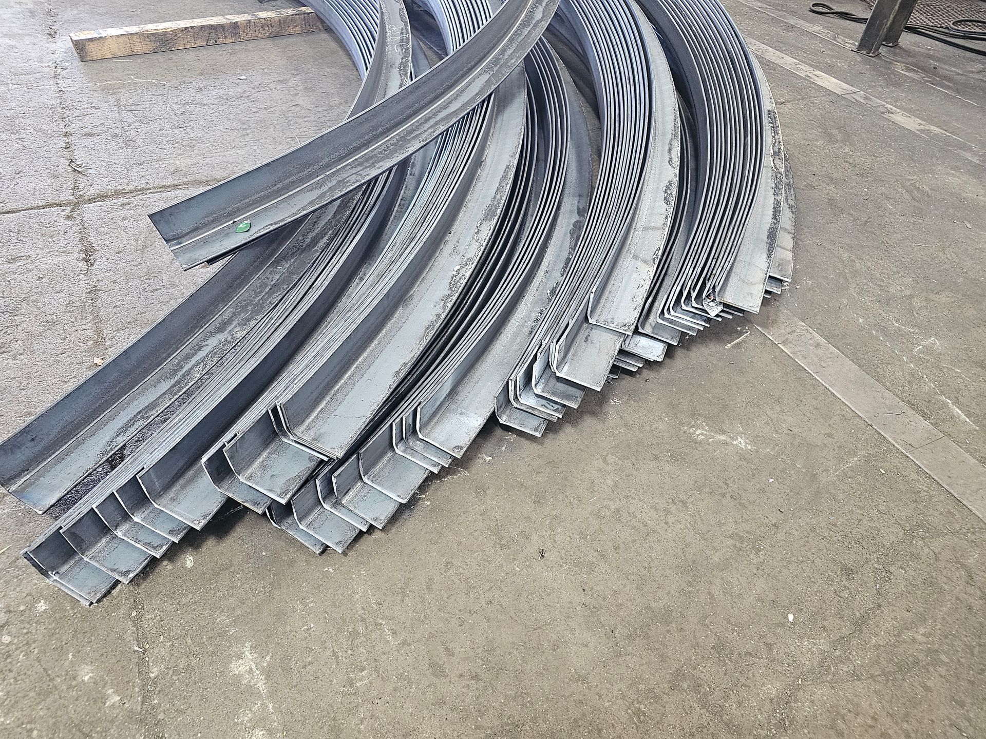 A bunch of metal pieces are stacked on top of each other on the ground.