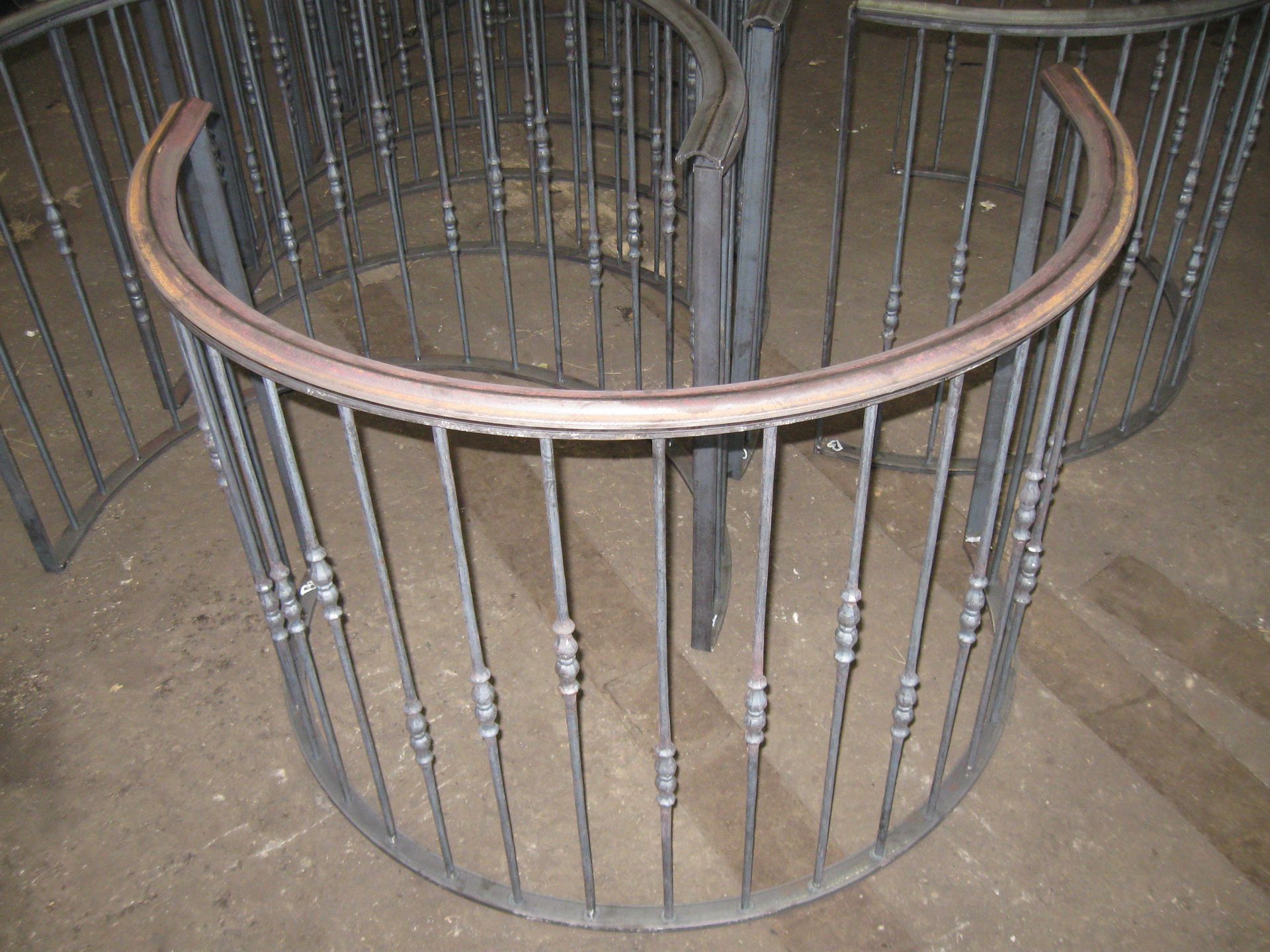 A circular metal railing with a wooden handrail