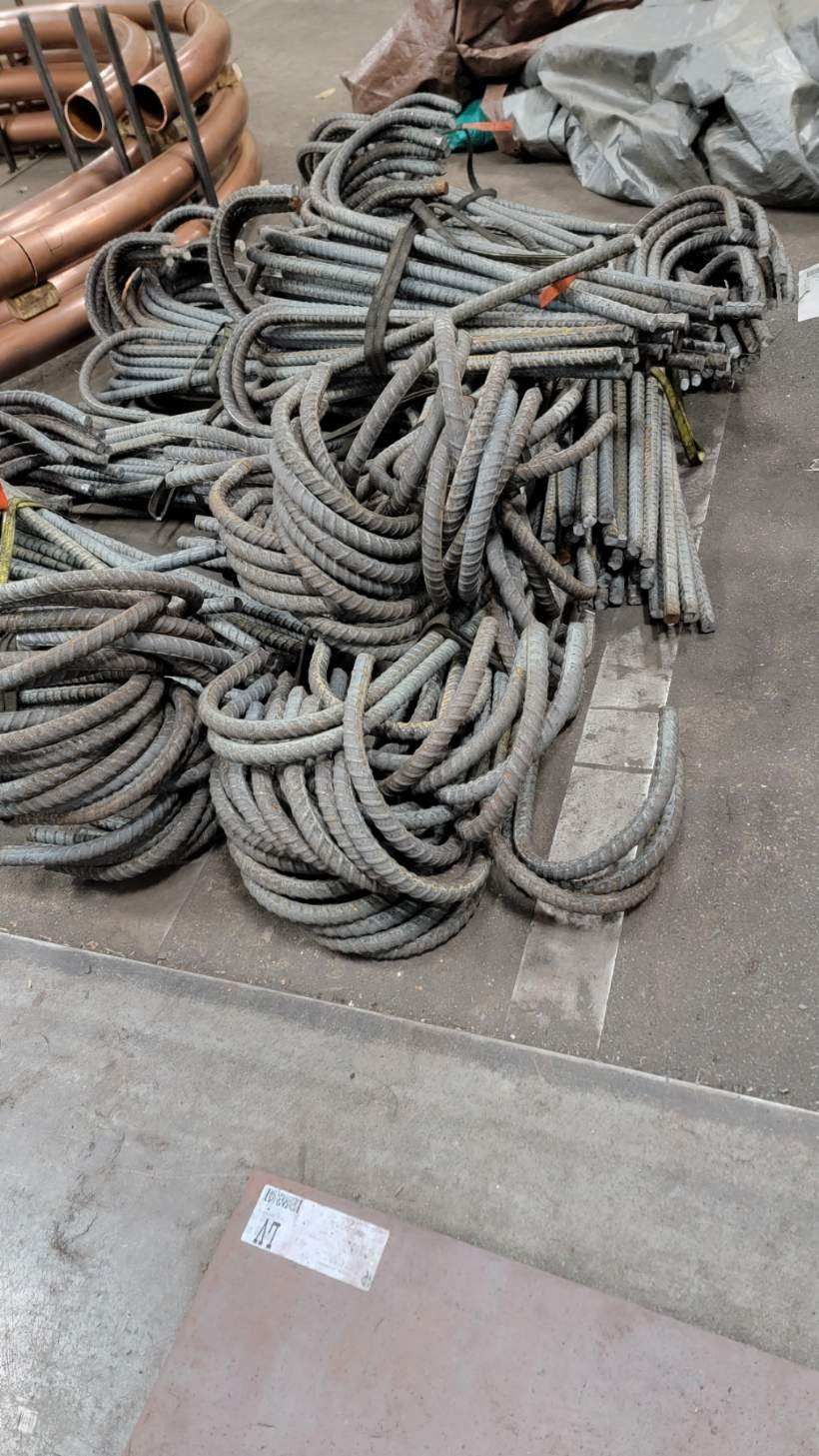 A bunch of metal ropes are stacked on top of each other on the floor.