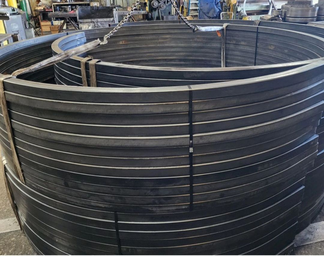 A large circular metal structure is being built in a factory.