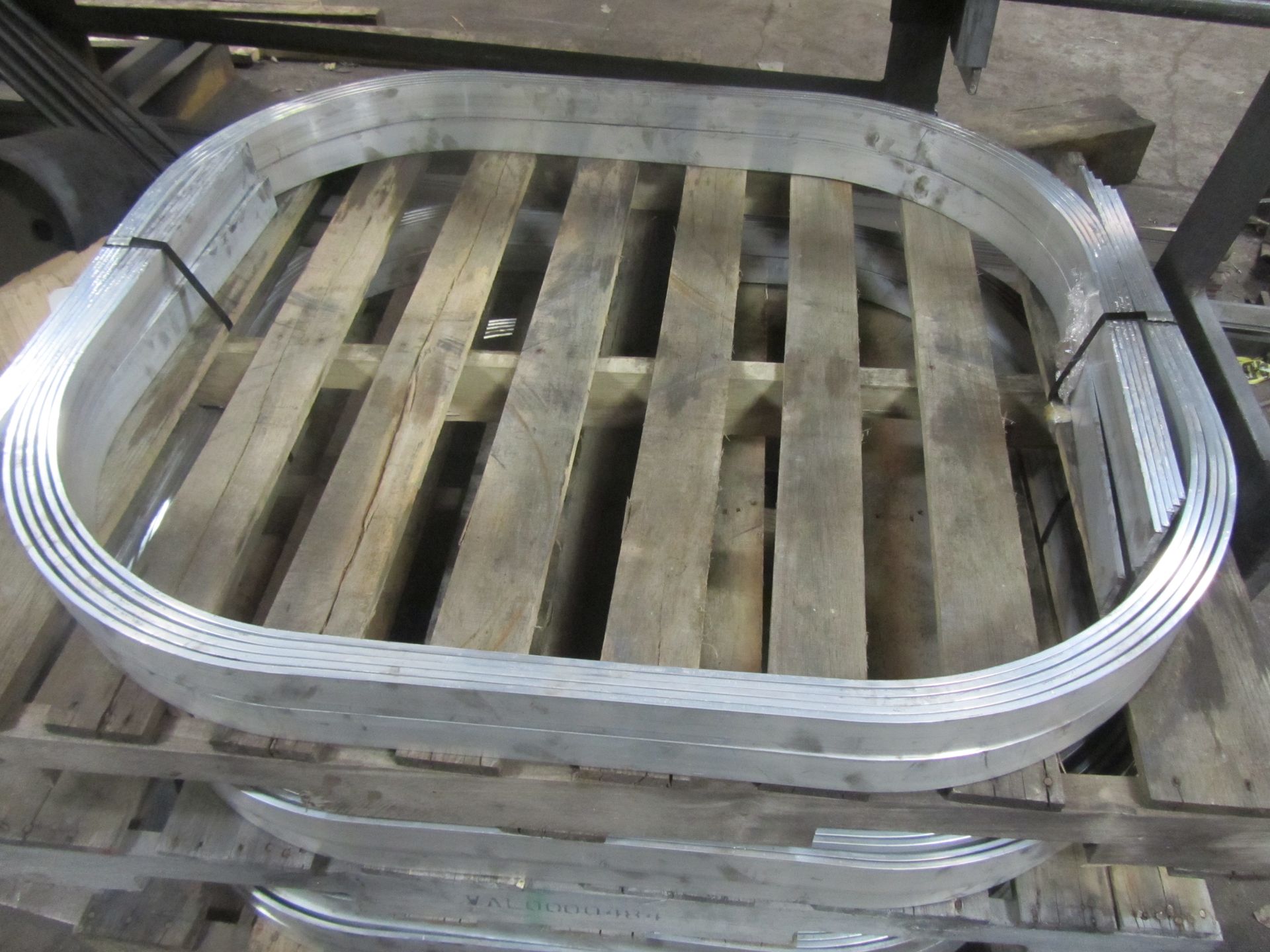 A stack of metal rings sitting on top of a wooden pallet